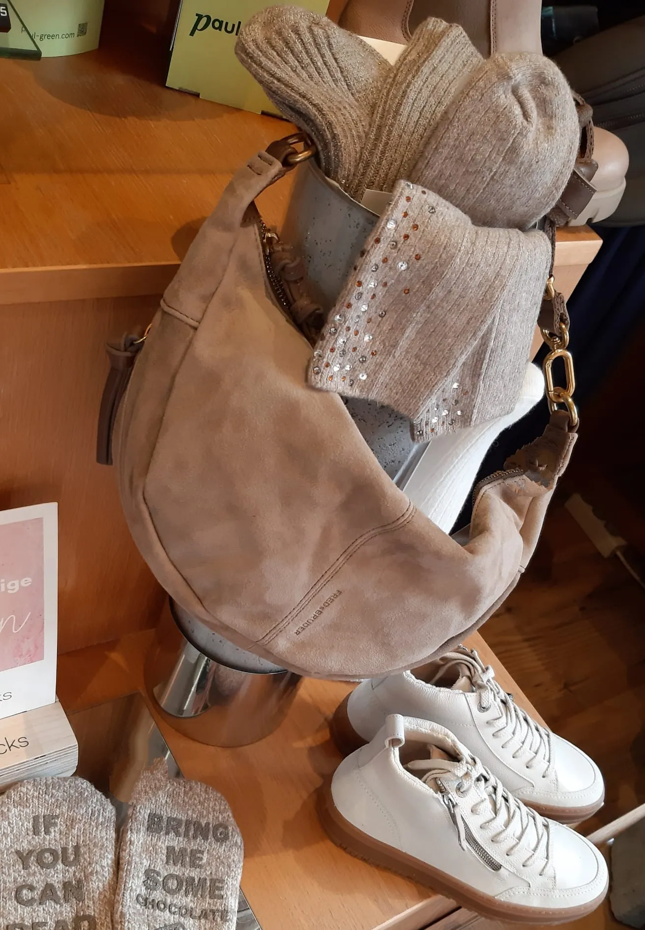 Taupefarbene Beuteltasche mit Strick-Accessoires und Sneakern
